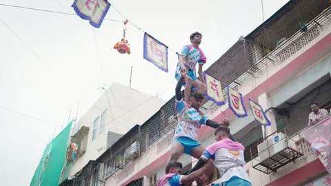 Young men balancing on each other to form a pyramid during Janmashtami festival Stock Footage 281932366