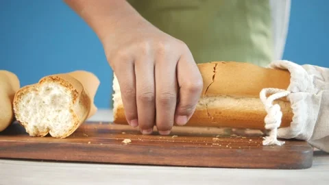 Young men breaking a long bread of loaf Stock Footage