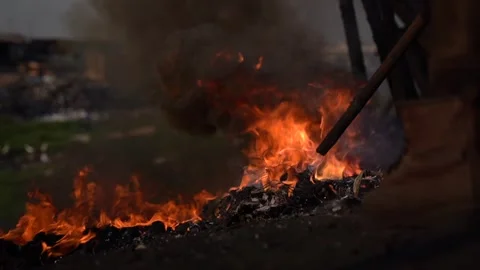 Young men is burning e-waist during day time in Agbogbloshie, Ghana Stock Footage 243590819