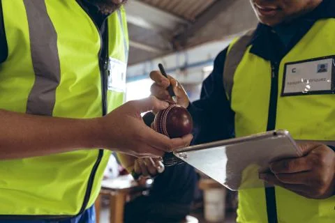 Young men checking quality and using tablet in a sports equipment factory Foto stock