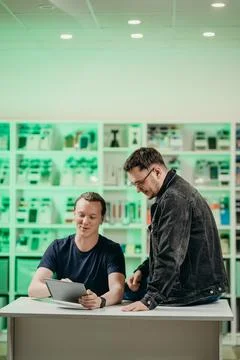 Young men communicate in a hardware store, discuss Stock Photos