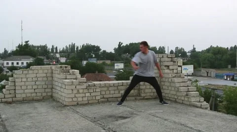 Young men doing a freerunning jumping and flipping stunt. Stock Footage 67316180