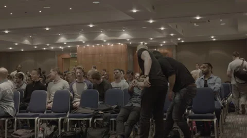 Young Men Greeting and Talking in Conference Hall Audience Stock-Footage 342565333