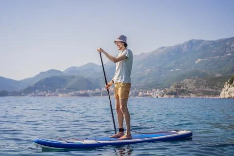 Young men Having Fun Stand Up Paddling in blue water sea near st stefan island Stock Photos