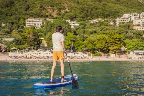 Young men Having Fun Stand Up Paddling in blue water sea near st stefan island Stock Photos