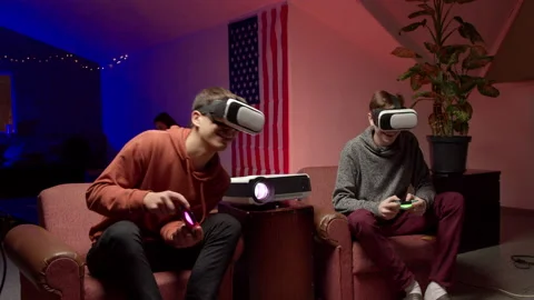 Young men in headsets playing virtual videogame together Stock Footage 147398771
