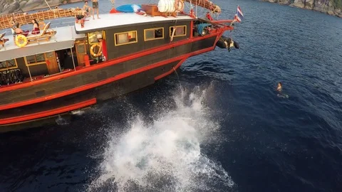 Young men jumping off boat summer fun Video stock 77716893