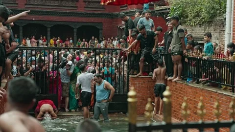 Young Men Jumping into Pond during Gai Jatra Festival in Harisiddhi, Nepal Stock Footage 318717977