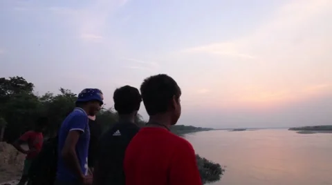 Young men look out over the Ganges River Stock Footage 65708967