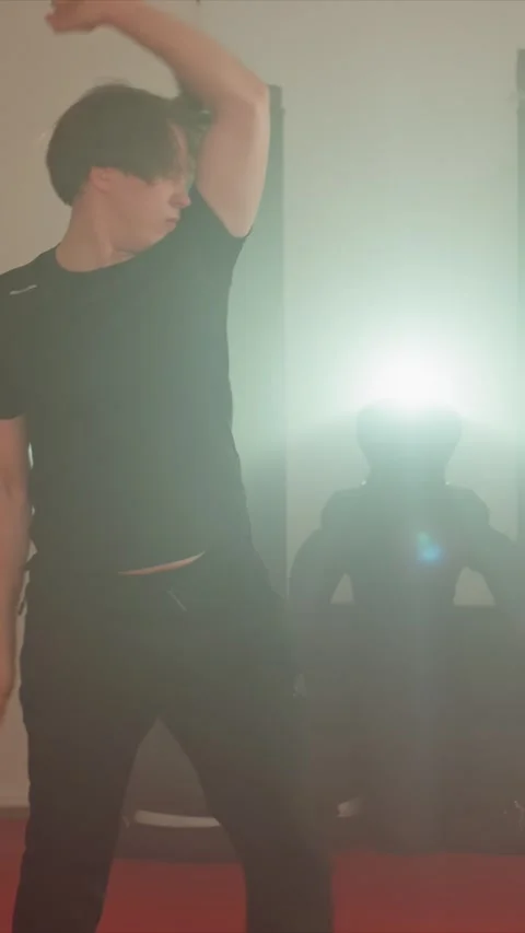Young men perform dynamic movements in indoor setting with beige walls and red Vídeos de archivo 347611767