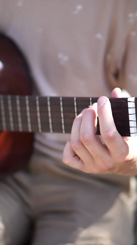 Young men is playing acoustic guitar outside Stock Footage 283576359