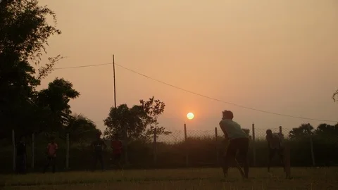 Young men playing cricket at sunset Bangladesh Stock Footage 95288179