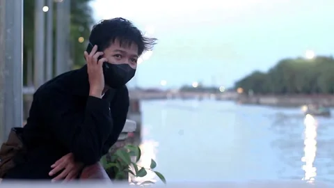 Young men playing phone at park Stock Footage 169357744