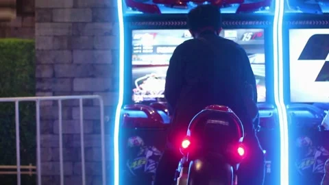Young men playing toy Motorcycle at amusement Center Stock Footage 169353942