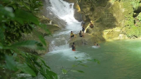 Young men playing in the water by a waterfall, in the Philippines Stock Footage 235487084