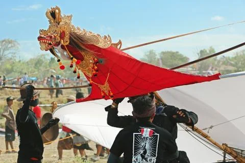 Young men preparing to launch a huge kite with a dragon head Stock Photos