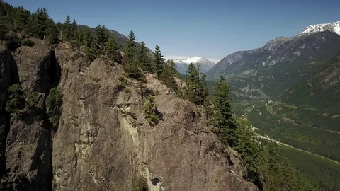 Young Men Sitting On The Edge Of A Cliff With Beautiful Mountain Views  Video stock 78657283