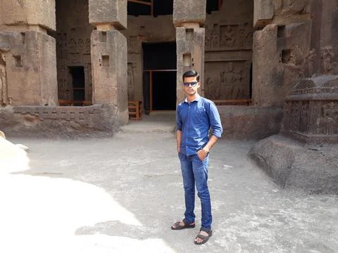 Young men standing front of cave, Kanheri caves with a men, blue shirt wearing. Stock Photos