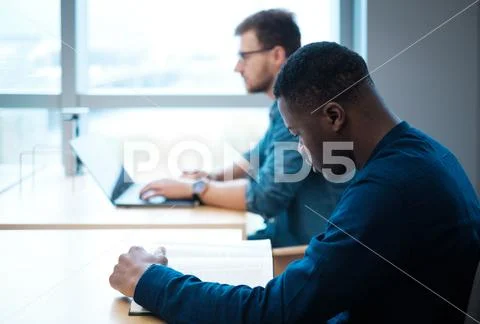 Young Men Studying In Public Library