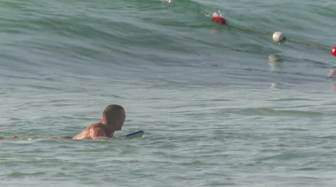 Young men swimming in waves on board hd phuket thailand Stock Footage 64565160