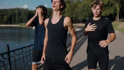 Young Men Taking a Break After Jogging Together in Summer Evening Park Stock Footage 315348085