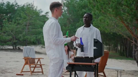Young men talk while cooking barbecue at the party in the woods 스톡 동영상 197167898