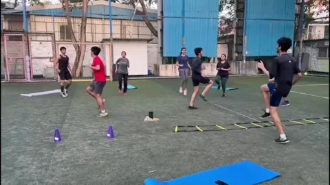Young men training hard on turf ground performing agility and speed exercises Stock Footage 251472769