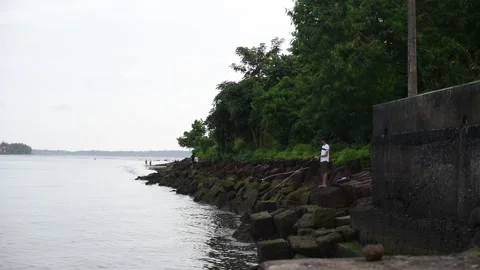 Young men trying their hand at fishing in the river using a fishing rod and bait Stock Footage 159615834