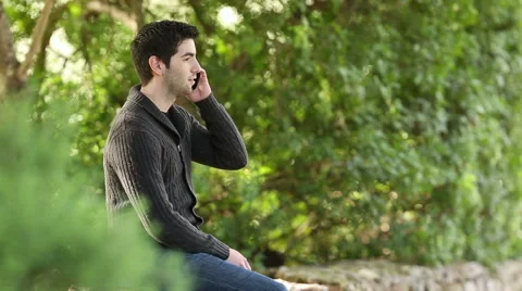Young men using smart phone in  a green park Stock Footage 44939516