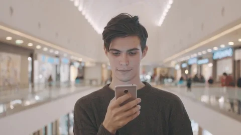 Young men using smartphone at shopping mall. Portrait Stock Footage 70189147