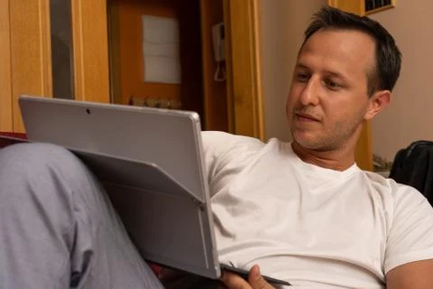 Young men using tablet at home laying at his sofa Stock Photos