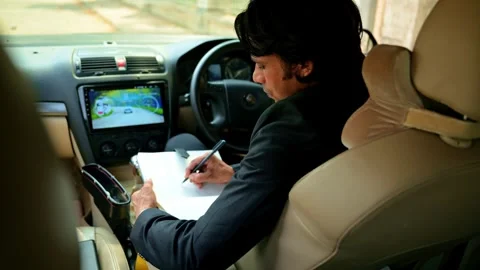 Young men write on book inside car Stock Footage 277035483