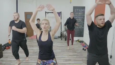 Young men on zumba class warming up by dancing in a gym studio led by a femal Stock Footage 87203077