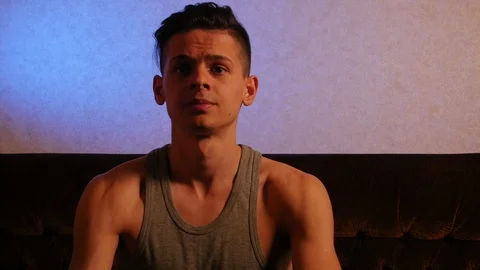 Young mensive guy sitting on the sofa oin the room 库存影片 106361066