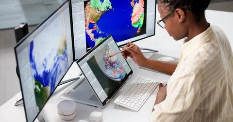 Young Meteorologist Uses Computer To Research Climate Change Forecasts. Stock Photos