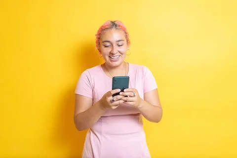 Young Mexican student smiling using cell phone. Hispanic sending messages Photos