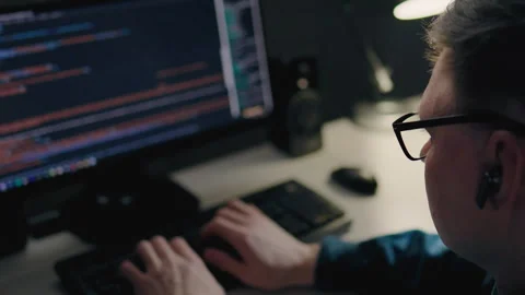 A young middle-aged programmer works remotely in his city apartment at night Stock Footage 241690562