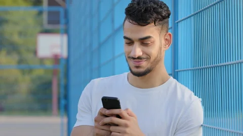 Young Middle eastern Arabic athlete in summer sportswear holding mobile phone Stock Footage 161903111