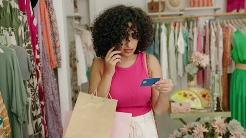 Young middle eastern woman customer talking on smartphone holding credit card Video stock 220150933