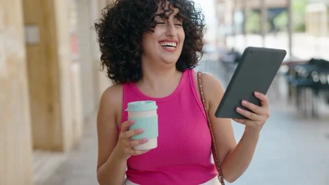 Young middle eastern woman using touchpad drinking coffee at street Video stock 206535413