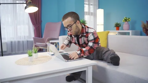 Young midget man freelancer, student, working online from home using laptop. Stock Footage 230975523