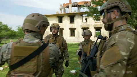 Young military soldiers troop with weapons discussing a strategy plan during Stock Footage