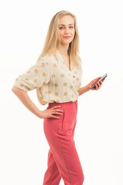 Young millennial blond long-haired girl in red pants and white dotted cardigan Stock Photos