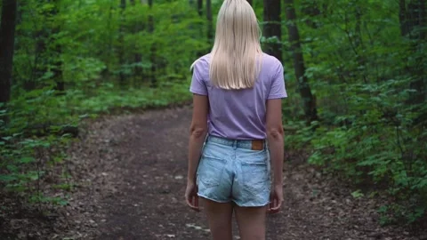 Young millennial woman walking throught the summer forest Stock Footage