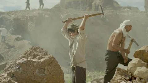 Young miner boy is working in a quarry . Many workers are mining with pickaxe Stock Footage 123506080