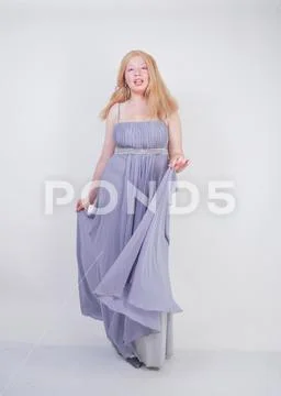 Young mix race happy adult woman in a grey long shiffon evening wear Stock Photos