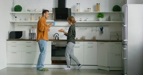 Young mixed couple has fun in kitchen, enjoying their weekend morning Stock Footage 114910005