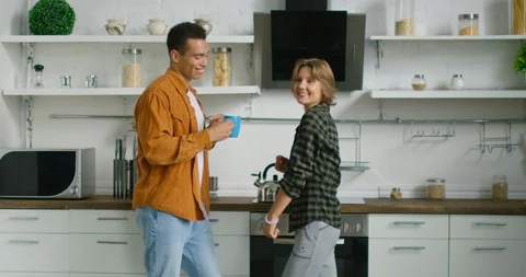 Young mixed race couple is dancing in kitchen, enjoying morning time Stock Footage 114641663