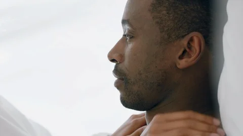 Young mixed race couple lying in bed kissing under sheets sharing romantic Stock Footage 109514431