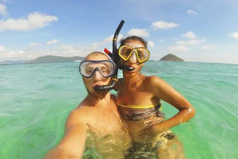 Young Mixed Race Couple Making Selfie Photo Using Waterproof Camera in Clear Stock Photos